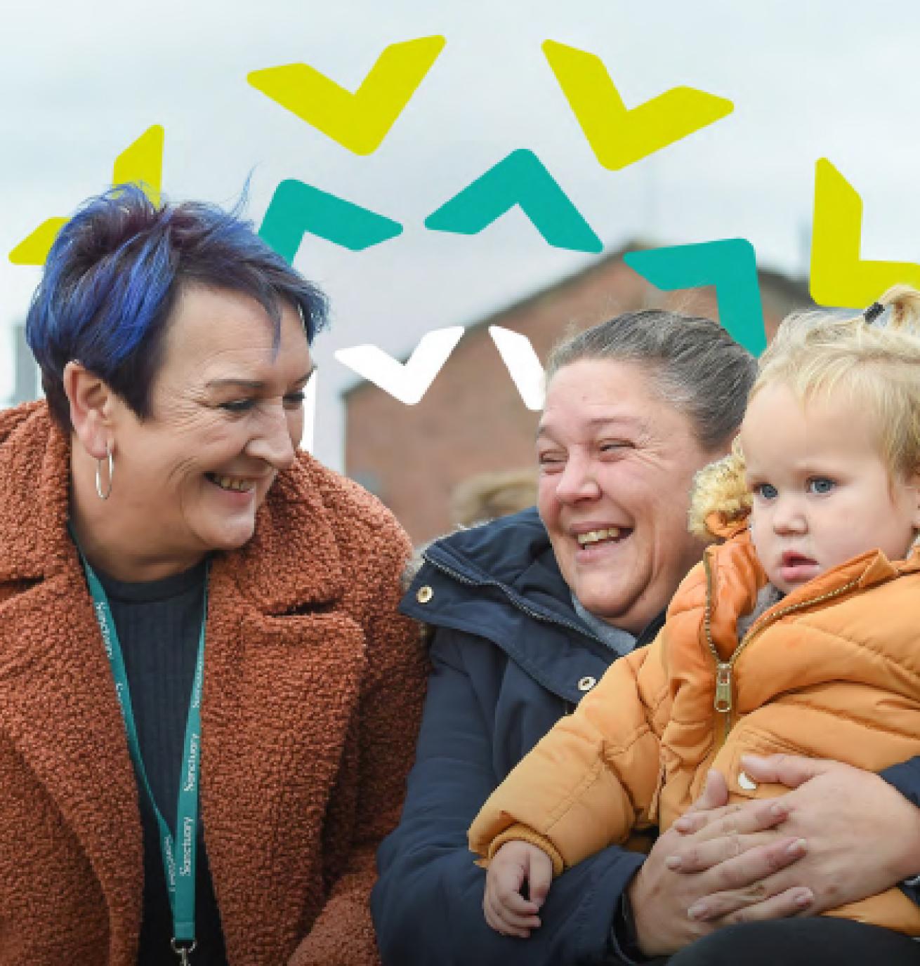 Housing Office smiling at a Sanctuary resident who is also smiling and holding a small child