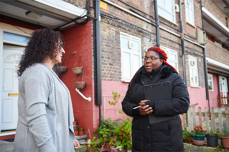 Sanctuary staff speaking to a resident outside their home