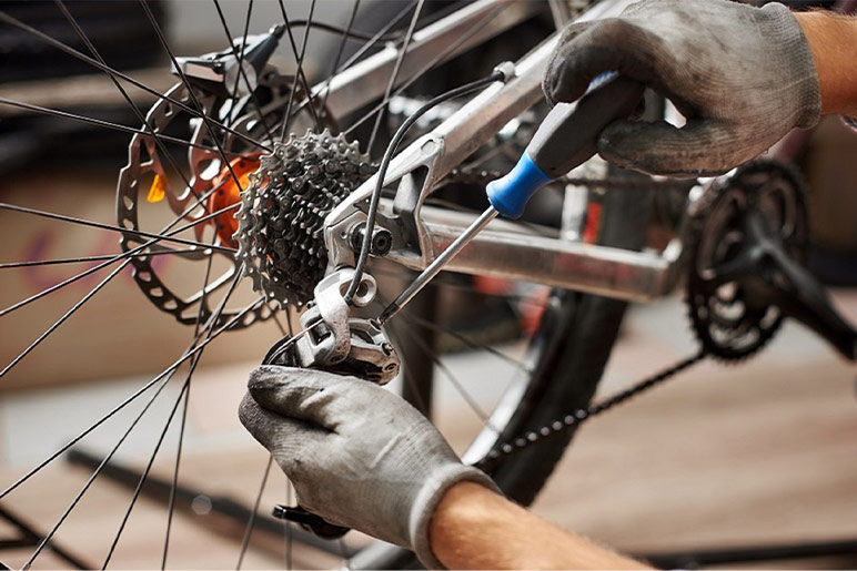 Stock image of a mechanic working on a bicycle chain