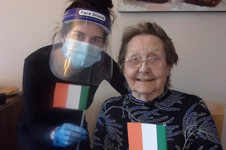 Jessica waves handmade Irish flags with resident, Elsie