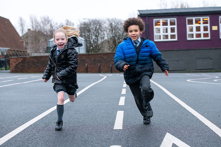 School children running in a playground