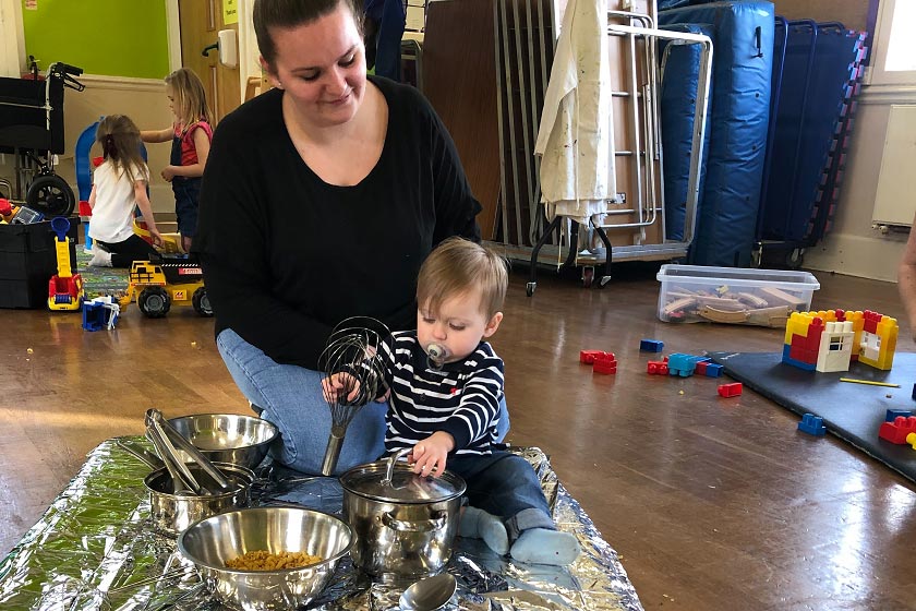 A mum and her child play on an activity mat.