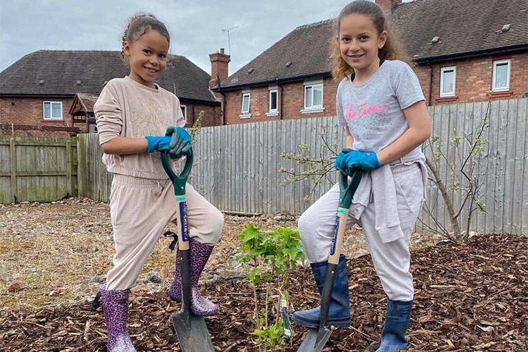 Malika and Tiyana Newey planting a tree at our Lache Growing Space