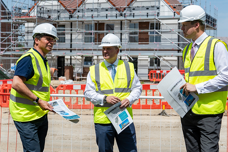 Craig Moule, Nigel Huddleston and Mark Battin in high vis jackets standing in front of the Evesham development.