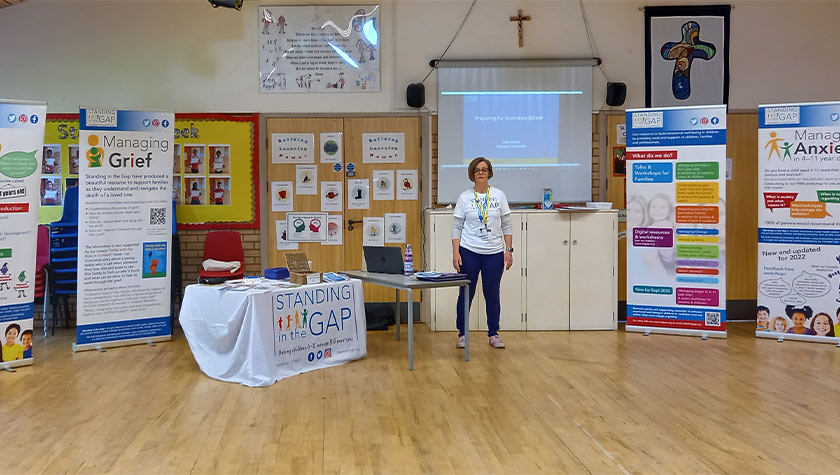 Standing in the Gap representative giving a presentation in a school hall