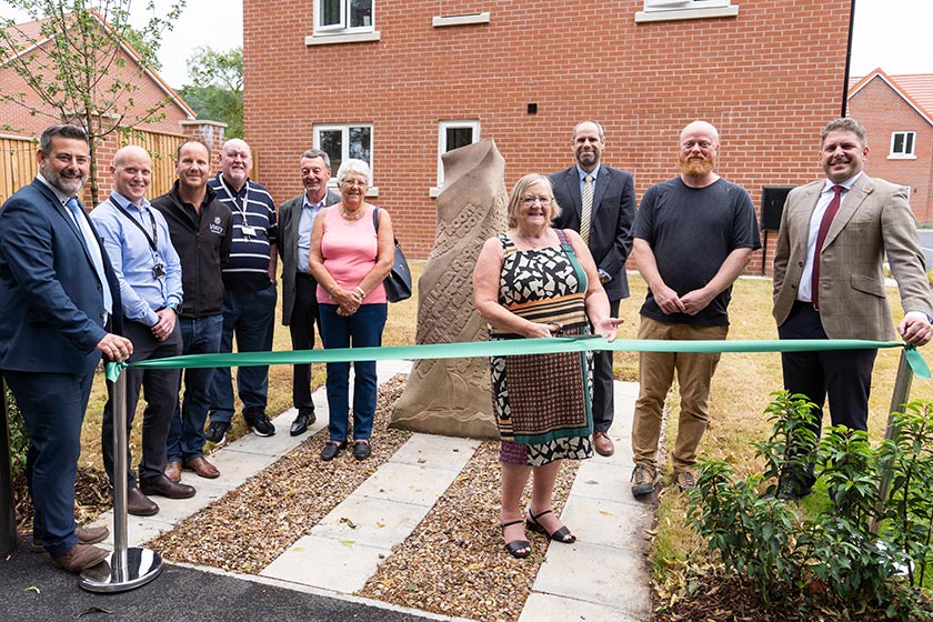 Cllr Jean Innes, joined by other borough and parish councillors, as well as Sanctuary and partner staff, cuts the ribbon on the site