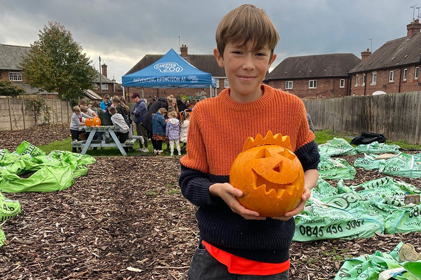 Caleb Hogg holding a carved pumpkin for Halloween