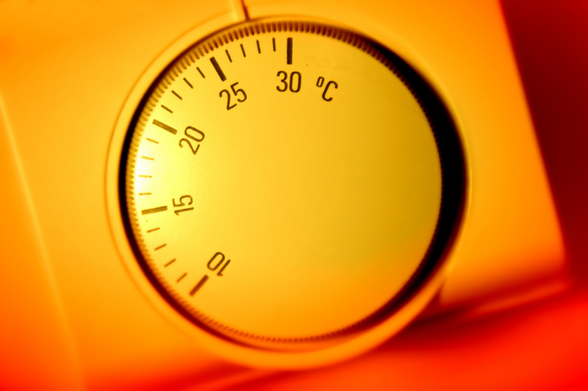 A thermostat is shown surrounded by a warm orange glow