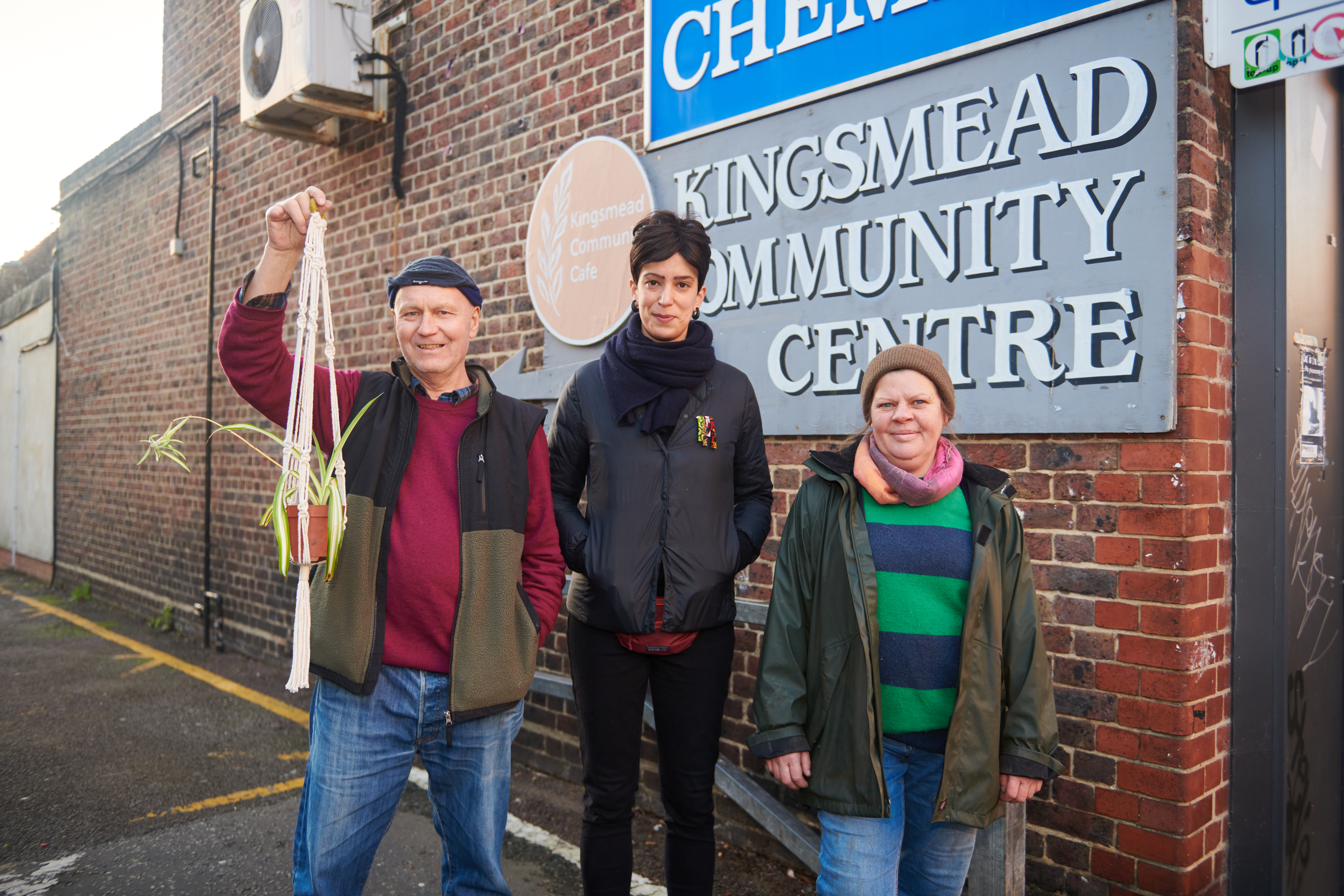 Three people are shown in front of a sign reading Kingsmead Community Centre