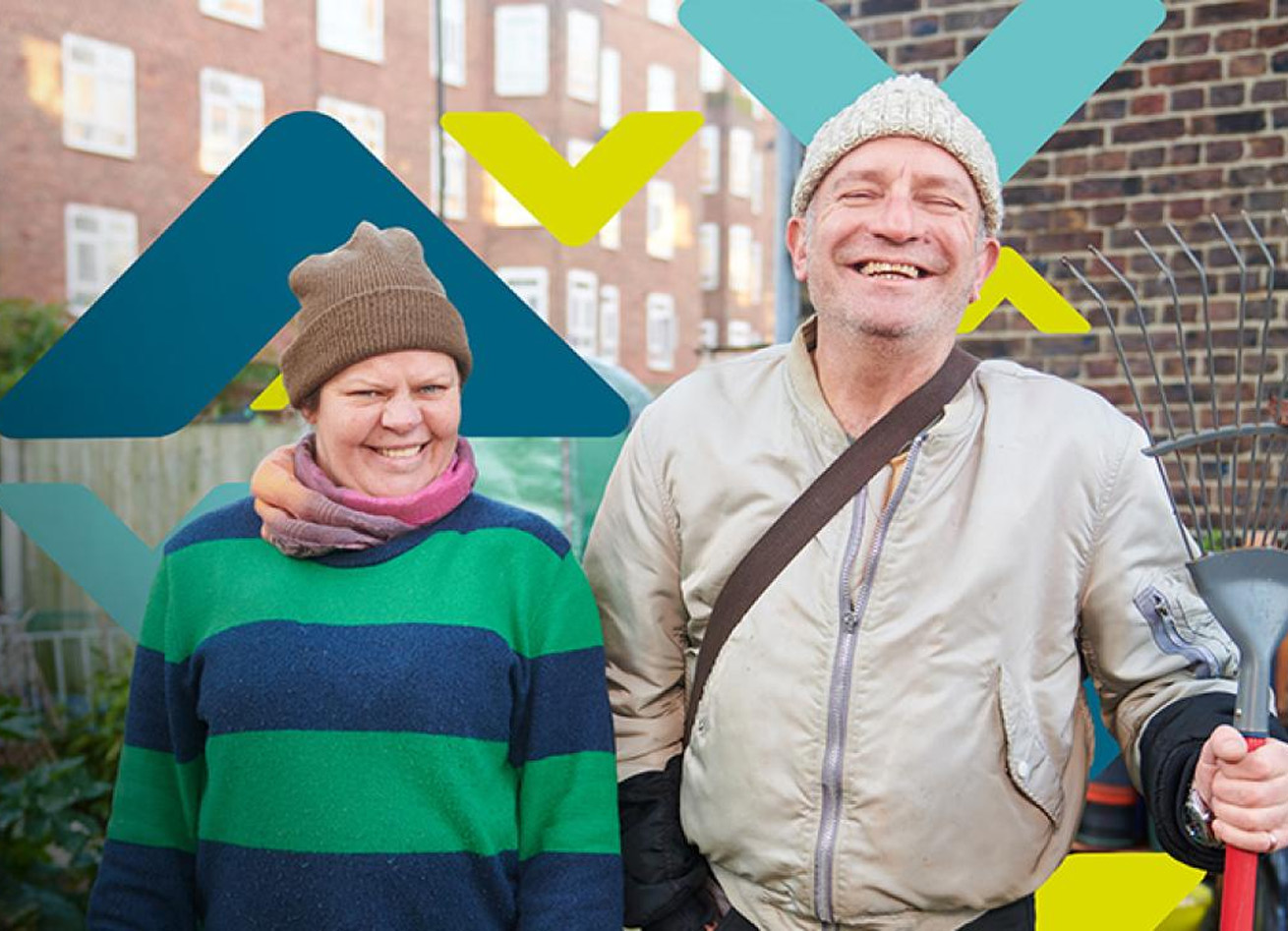 Two residents smiling, standing in an allotment