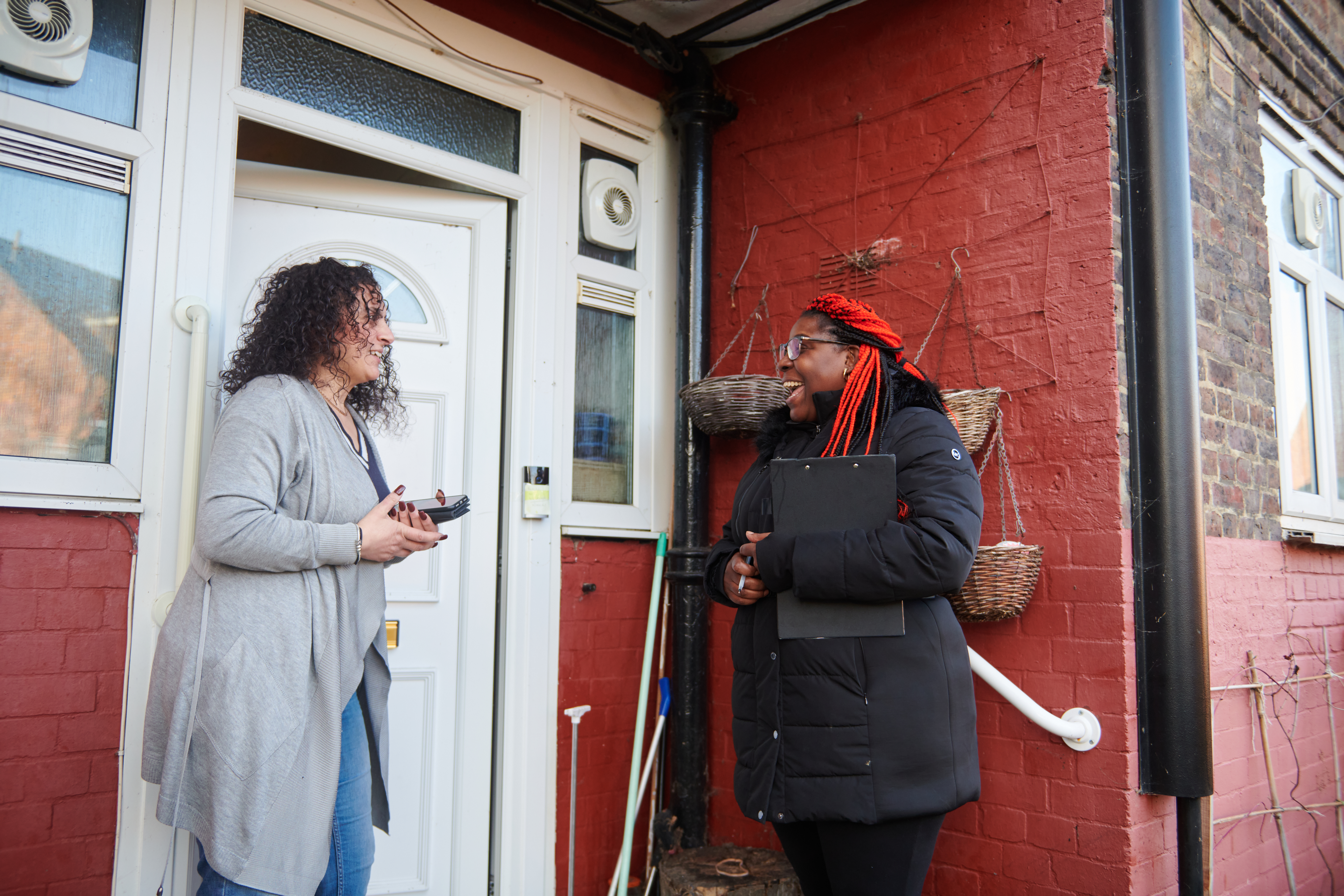 Sanctuary staff speaking to a resident outside their house