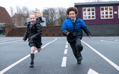 School children running in a playground