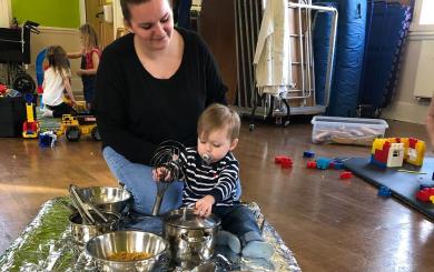 A mum and her child play on an activity mat.