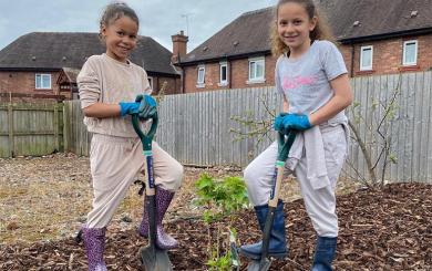 Malika and Tiyana Newey planting a tree at our Lache Growing Space