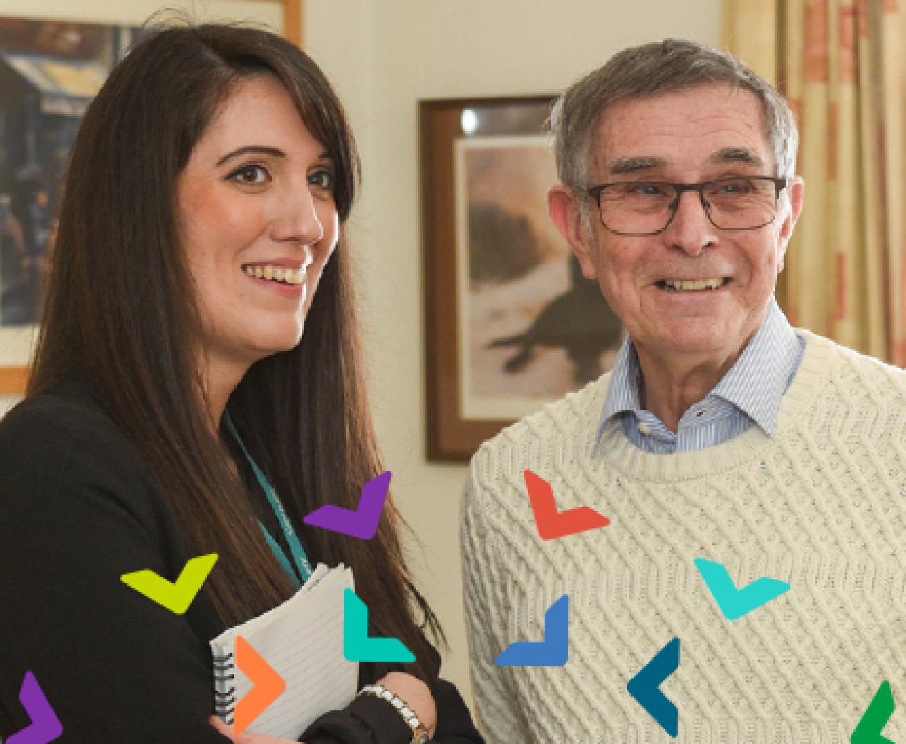 A woman and an older man standing in a resident's living room 