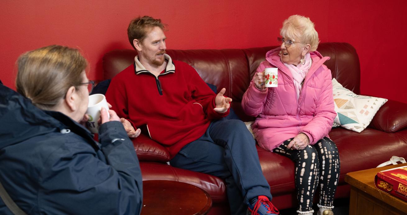 Sanctuary residents sat on a sofa while meeting their housing officers