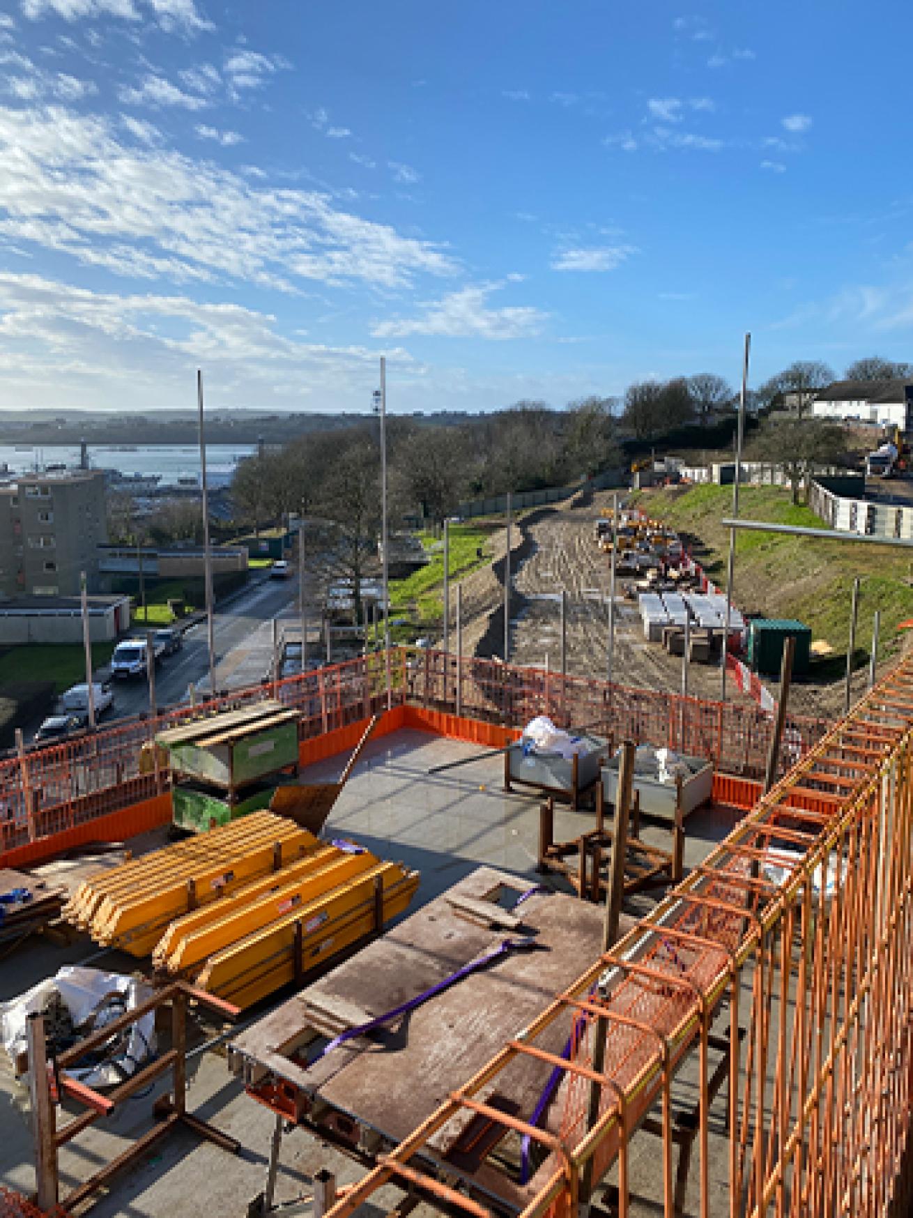 Aerial view of a building site with piles of building materials on top of a scaffolding platform