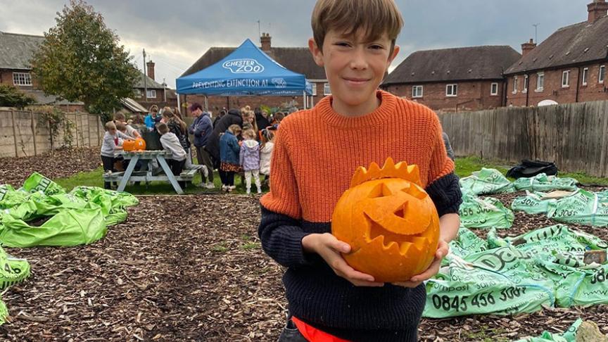 Caleb Hogg holding a carved pumpkin for Halloween