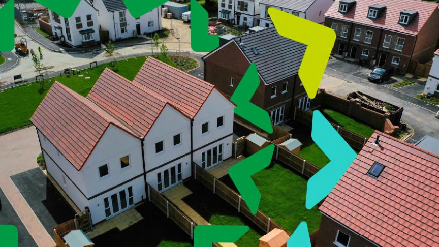 Aerial photograph of a housing development with terraced, semi-detached and detached homes with gardens separated by wooden fences